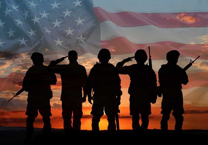 shutterstock_2441037953-1 Soldiers saluting at sunset with American flag overlay