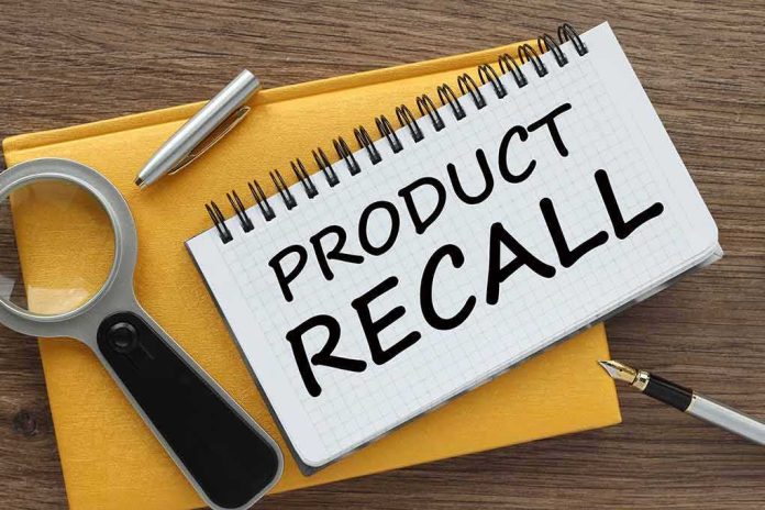 shutterstock_2458105629 Notebook with product recall note beside magnifying glass and pen