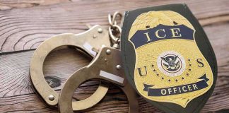 ICE officer badge and handcuffs on wooden surface