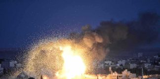Large explosion over a city at night