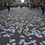 street covered with scattered flyers after a public event