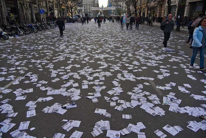 street covered with scattered flyers after a public event