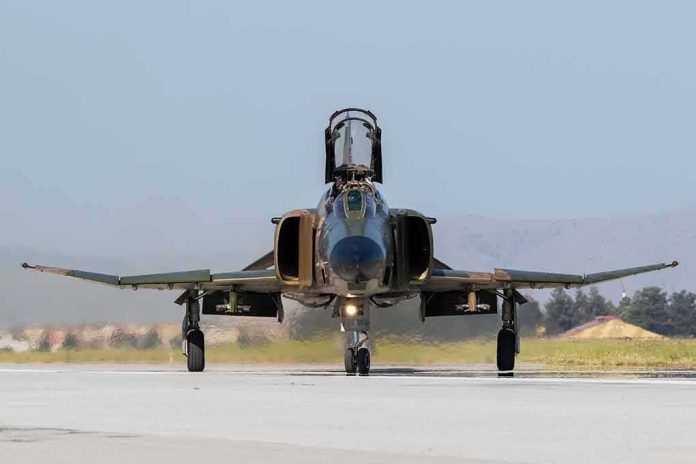 Military jet taxiing on runway with open canopy