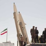Iran Threatens To Widen The War — The Embassies Moved FIRST Soldiers stand beside large missiles at an outdoor display