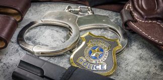 DA Says Cop INVENTED A Killer — And Names His REASON Handcuffs, officer badge, and firearm on textured surface.