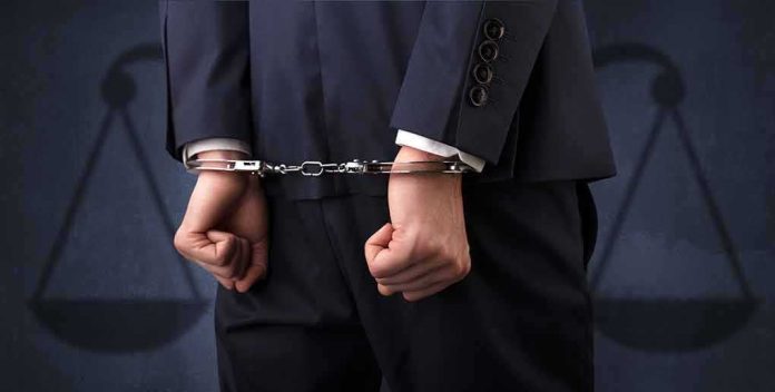 shutterstock_1104042224 Businessperson in handcuffs with hands behind back
