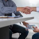 Democrat Mayor’s SHADY Donors — What She Told Them Two people shake hands over a desk while cash is exchanged underneath