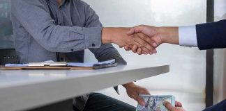 Democrat Mayor’s SHADY Donors — What She Told Them Two people shake hands over a desk while cash is exchanged underneath