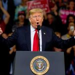 Trump Threatened, 3 Charged — The Third Threat Is Far DARKER Donald Trump speaking at a rally podium with arms raised