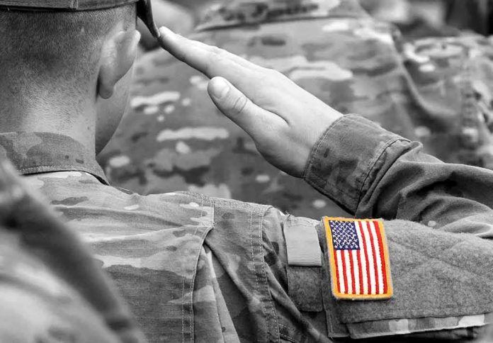 shutterstock_1220622835 Soldier saluting with an American flag patch on sleeve
