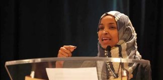Ilhan Omar speaking at a podium with a microphone