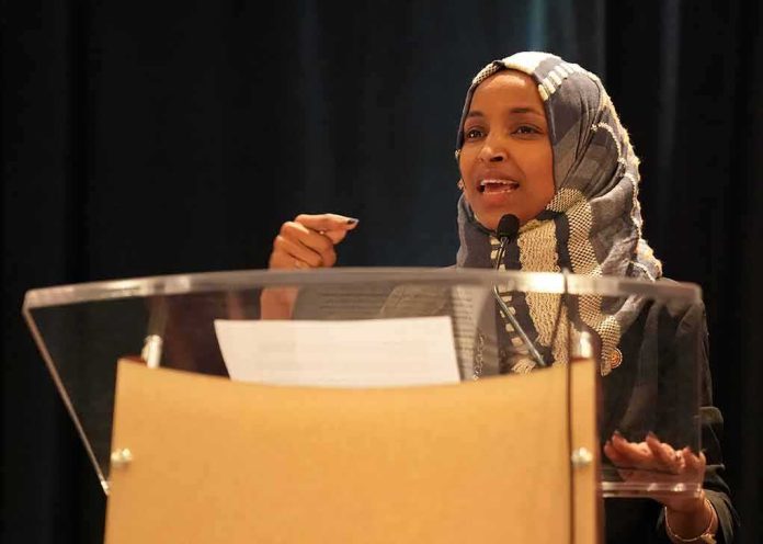 shutterstock_1282205566-1 Ilhan Omar speaking at a podium with a microphone