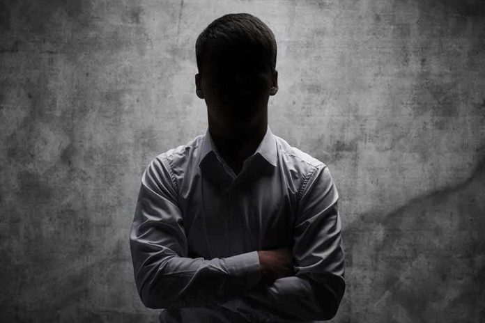 shutterstock_1382210507 silhouetted man in dress shirt with arms crossed