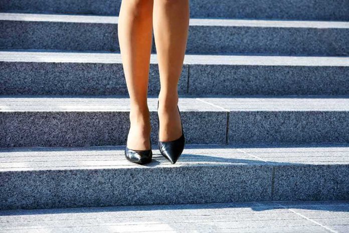 legs in black high heels walking down stone steps