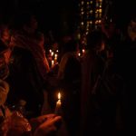 People holding candles at a nighttime vigil