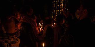 Where Mamdani Ate After The Oct. 7 Vigil Says It ALL People holding candles at a nighttime vigil