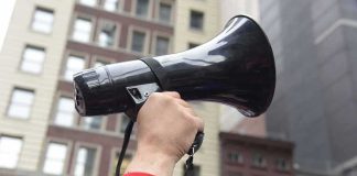 TOP Governor’s Netanyahu BOMBSHELL Hand holding a black megaphone in a city street