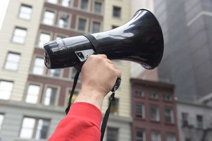 Hand holding a black megaphone in a city street