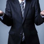 Businessperson in suit shrugging with open hands