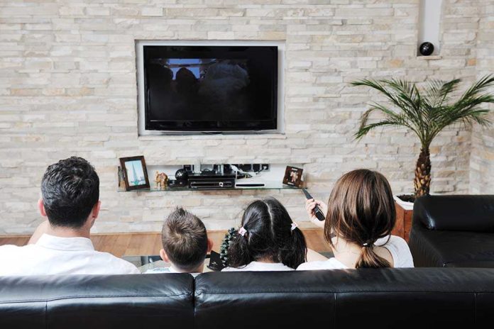 shutterstock_79170475-1 A family of four watching television together in a cozy living room